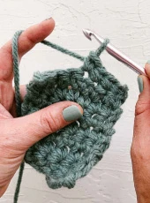 Handmade crochet materials and giraffe rattle arranged in a natural craft basket for Svamart